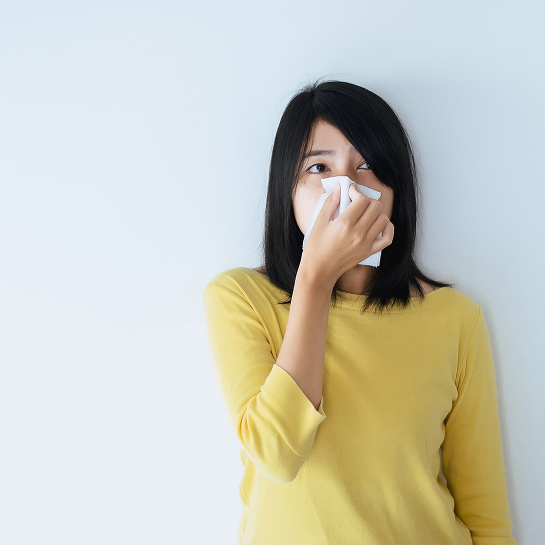woman holding tissue to face