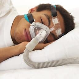Man in bed wearing a CPAP mask