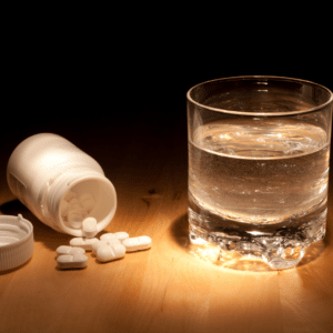 Medication on table next to glass of water