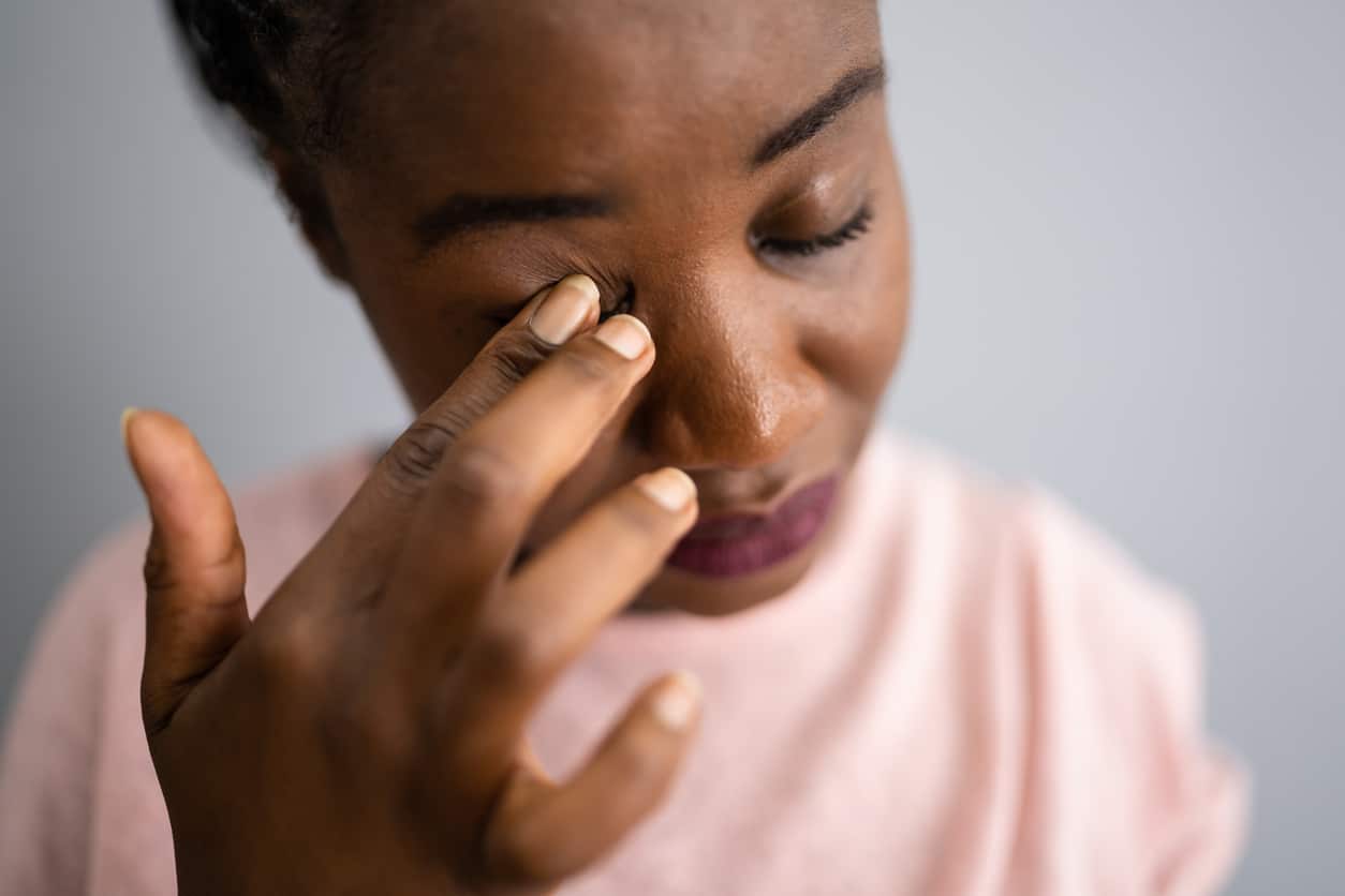 Woman scratches itchy eye