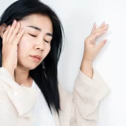 woman having problem with Meniere's disease, fainting or dizziness hand holding her head