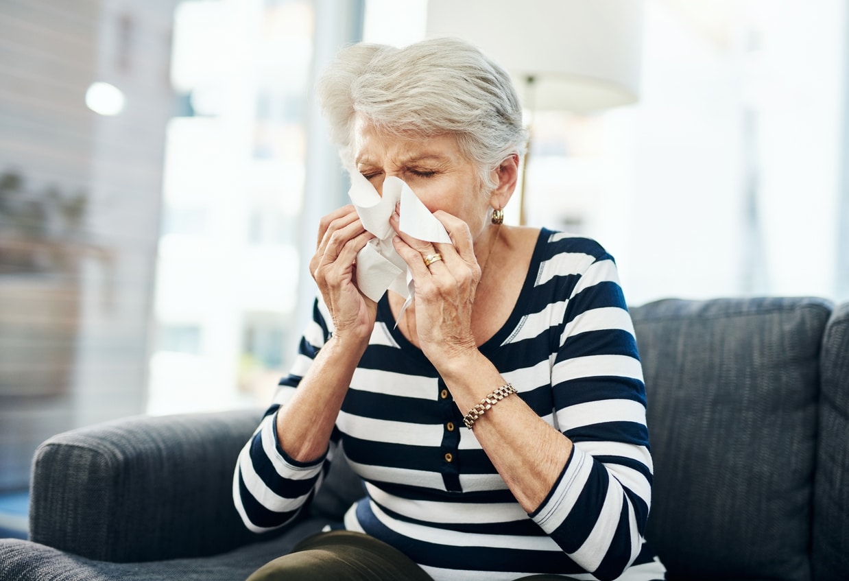 Woman blowing her nose into a tissue